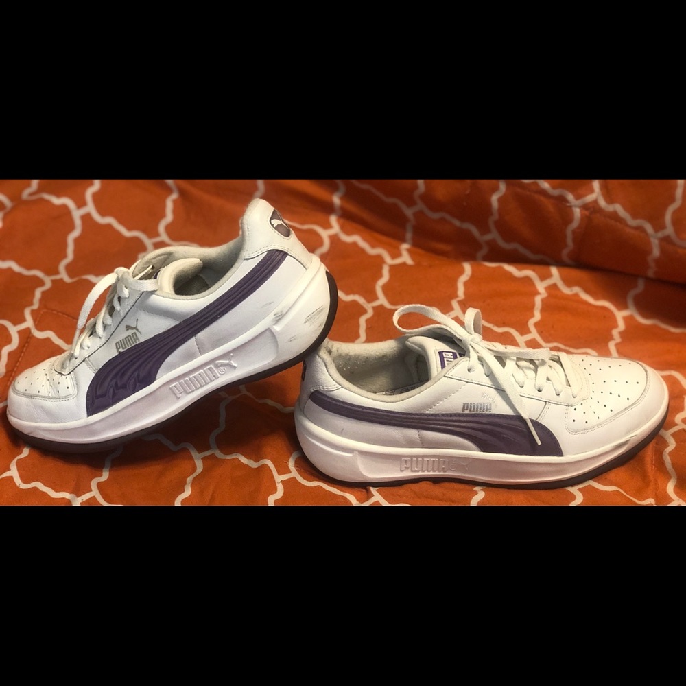 Classic white leather Pumas with purple stripe.